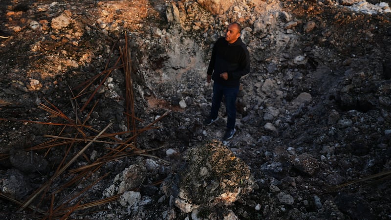 A man looks a the site struck by an Iranian missile in Zarzir, northern Israel, Friday, March...