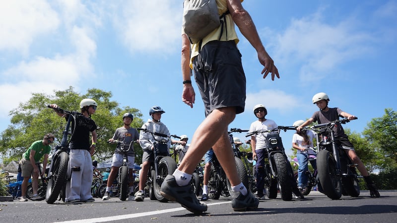 A group of riders listen to an instructor during an e-bike safety and training class Saturday,...